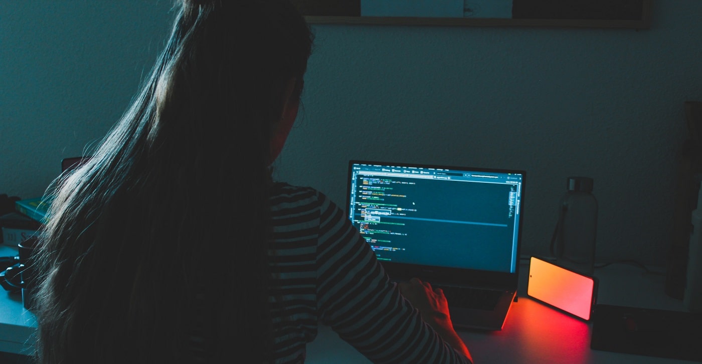 Student writing code at a laptop